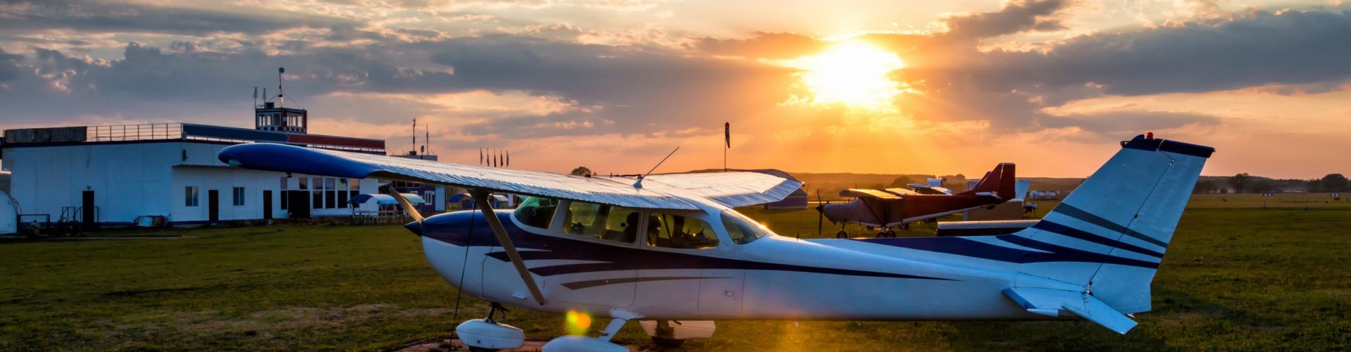 Small private airplanes on the airfield against the backdrop of a colorful sunset